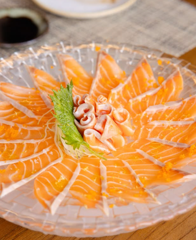 Sashimi de salmão em apresentação floral no prato cristal